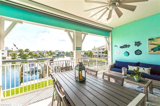 balcony featuring a water view, outdoor lounge area, and ceiling fan