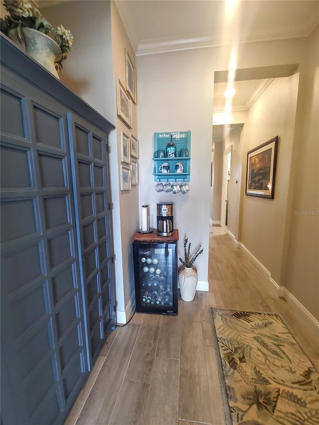 foyer entrance with crown molding, baseboards, and wood finished floors