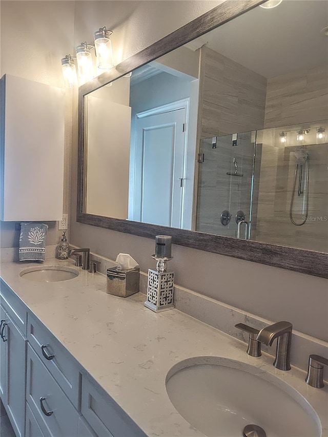 bathroom featuring double vanity, a shower stall, and a sink