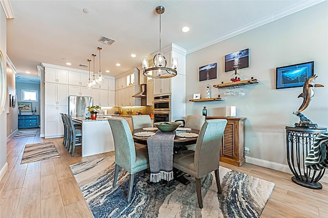 dining room featuring baseboards, light wood-style flooring, and crown molding