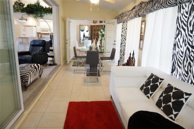 tiled living room featuring lofted ceiling, a healthy amount of sunlight, and ceiling fan