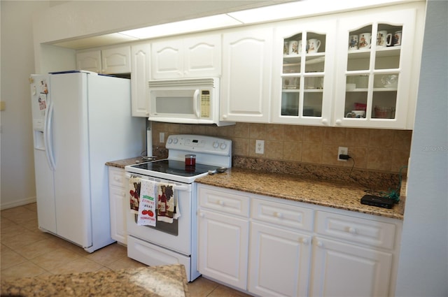 kitchen with backsplash, white appliances, light tile patterned flooring, and white cabinets