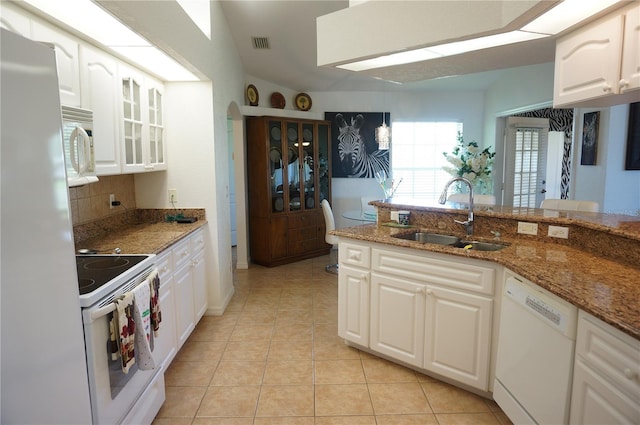 kitchen featuring sink, white cabinetry, light tile patterned floors, white appliances, and dark stone counters