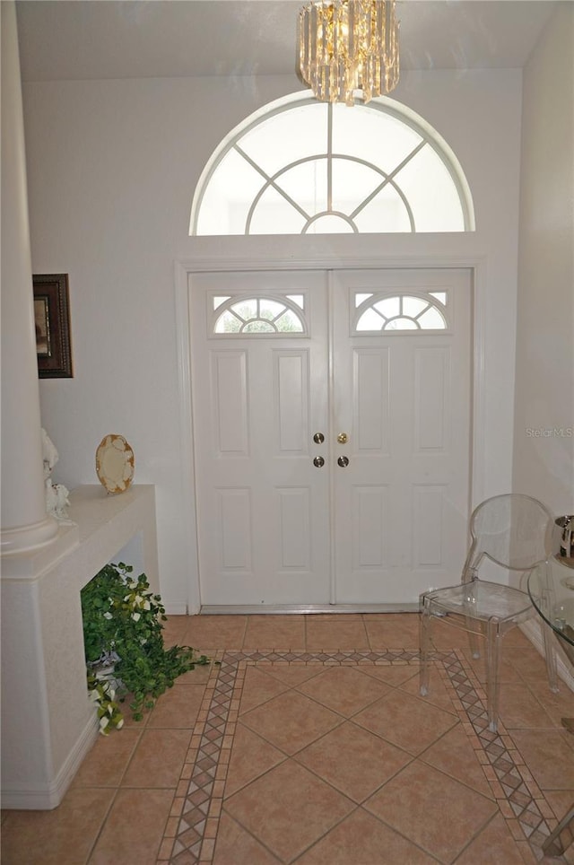 tiled foyer entrance with an inviting chandelier