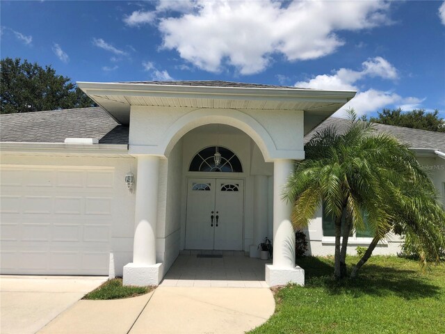 223 Valdiva St, Punta Gorda, FL 33983 - entrance to property with stucco siding, driveway, roof with shingles, and a garage