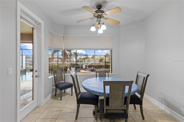 dining space featuring ceiling fan, light tile patterned flooring, and baseboards