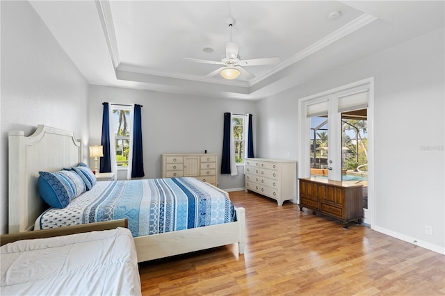 bedroom featuring baseboards, a raised ceiling, ceiling fan, light wood-style flooring, and ornamental molding