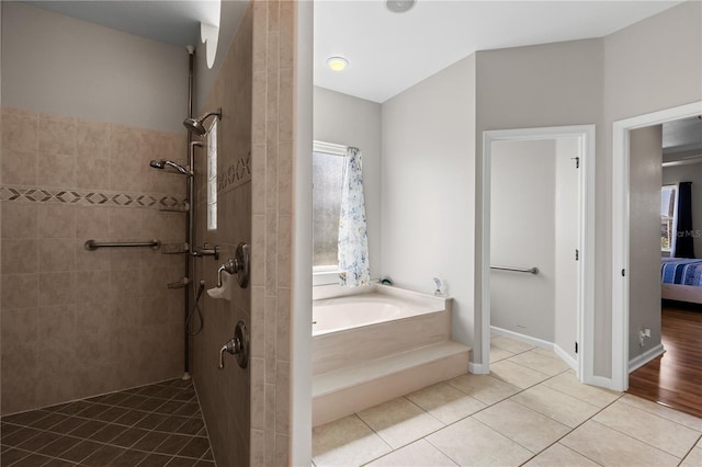 full bath featuring tile patterned flooring, a garden tub, connected bathroom, baseboards, and walk in shower