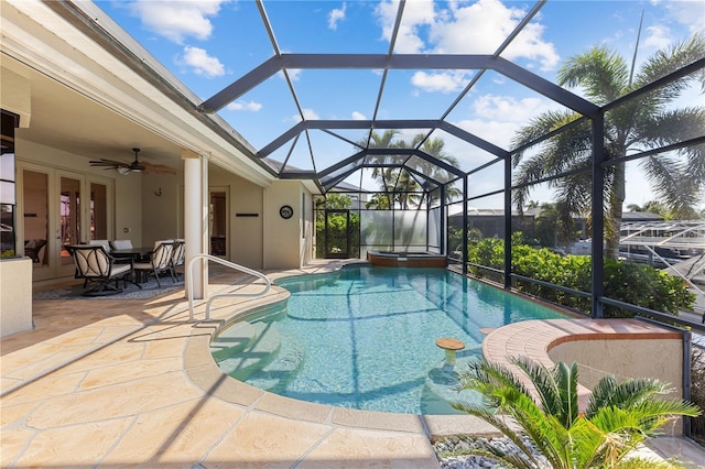 view of swimming pool with a patio, ceiling fan, a lanai, french doors, and a pool with connected hot tub