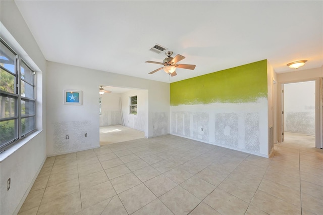 tiled spare room featuring ceiling fan