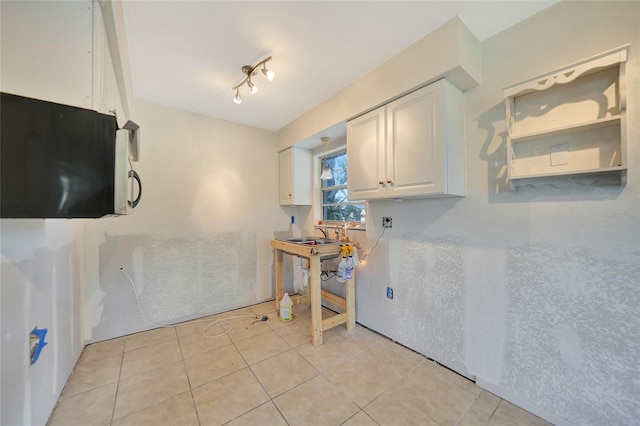 kitchen with white cabinetry and light tile patterned flooring