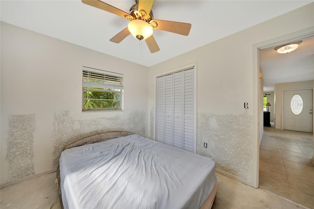 tiled bedroom featuring multiple windows, a closet, and ceiling fan