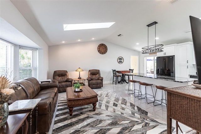 living room with lofted ceiling with skylight