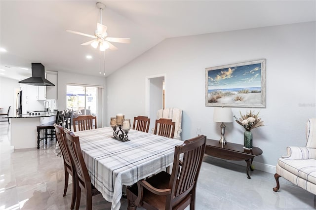 dining room featuring lofted ceiling, sink, and ceiling fan