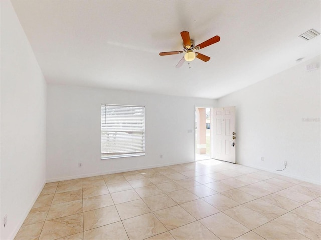 empty room with ceiling fan and light tile patterned flooring