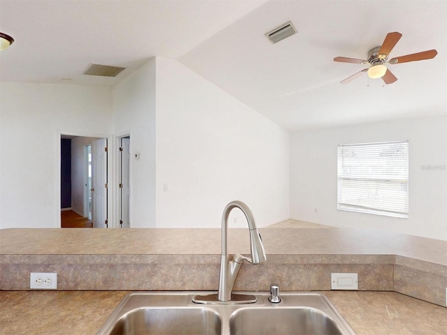 kitchen featuring ceiling fan, lofted ceiling, and sink