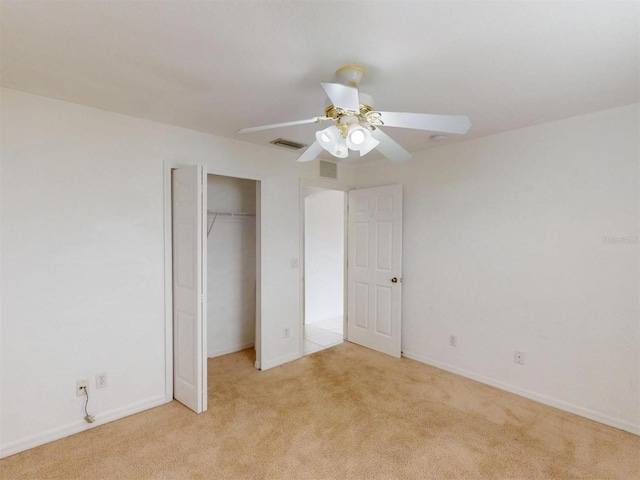 unfurnished bedroom with ceiling fan, light colored carpet, and a closet