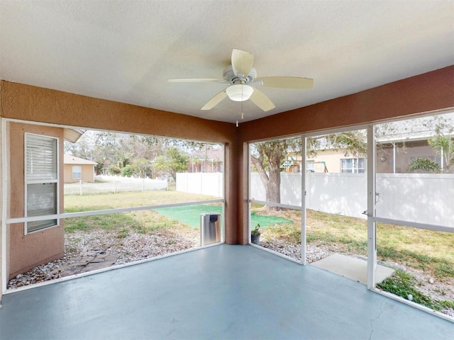 unfurnished sunroom with ceiling fan