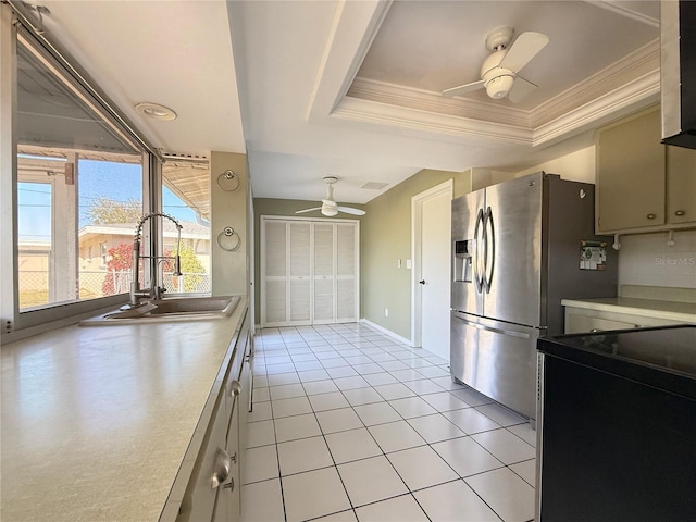 kitchen featuring sink, ceiling fan, stainless steel refrigerator with ice dispenser, a tray ceiling, and ornamental molding