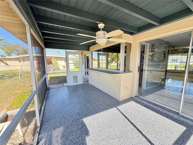 unfurnished sunroom with wood ceiling, ceiling fan, and beam ceiling