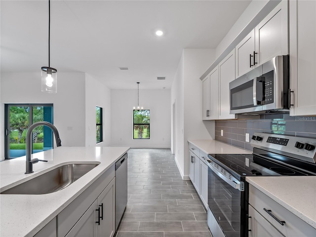 1818 New London St, North Port, FL 34288 - kitchen featuring stainless steel appliances, backsplash, decorative light fixtures, light stone countertops, and recessed lighting