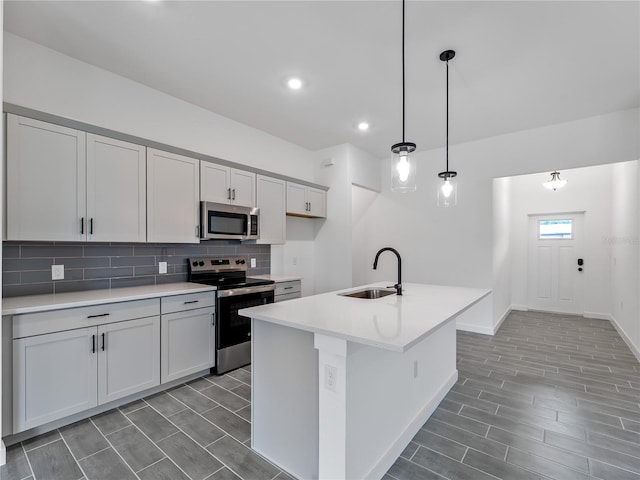 1818 New London St, North Port, FL 34288 - kitchen featuring appliances with stainless steel finishes, decorative backsplash, light countertops, pendant lighting, and a kitchen island with sink