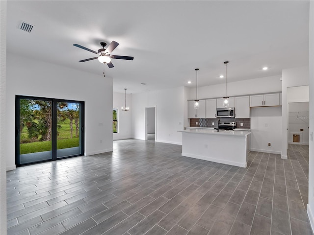 1818 New London St, North Port, FL 34288 - unfurnished living room with a ceiling fan, recessed lighting, a chandelier, and light wood-type flooring