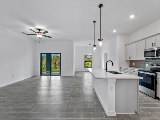 1818 New London St, North Port, FL 34288 - kitchen featuring stainless steel appliances, open floor plan, an island with sink, light countertops, and backsplash