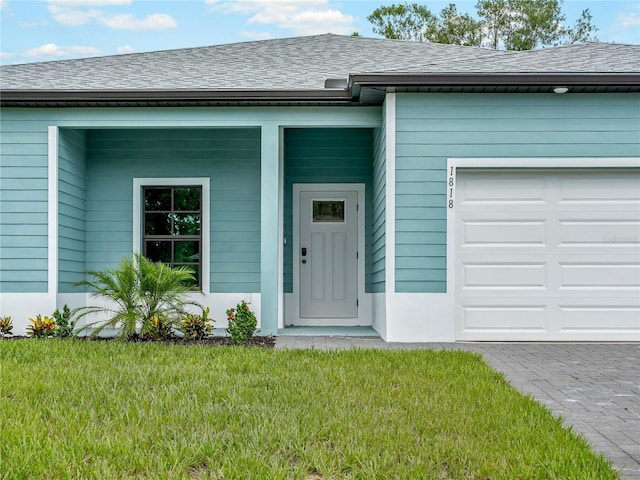 1818 New London St, North Port, FL 34288 - doorway to property with an attached garage, a shingled roof, and a lawn