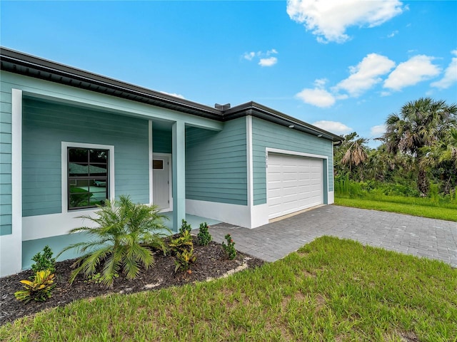 1818 New London St, North Port, FL 34288 - view of front of property featuring an attached garage, decorative driveway, and a front lawn