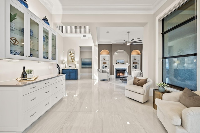 interior space with crown molding, ceiling fan, and built in features