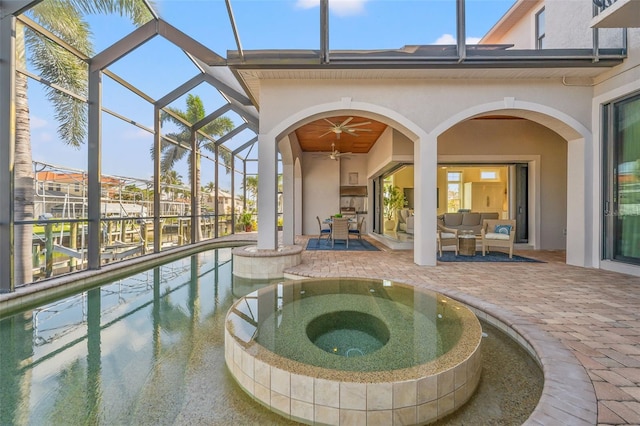 exterior space featuring a patio area, outdoor lounge area, a lanai, an in ground hot tub, and ceiling fan