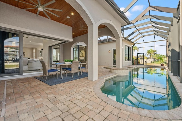 view of pool featuring ceiling fan, glass enclosure, and a patio area