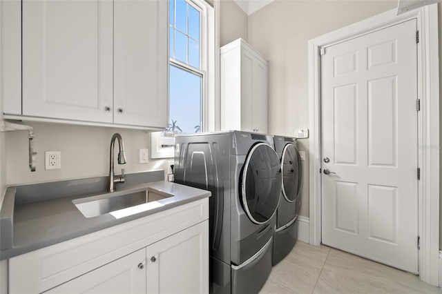 laundry area with cabinets, separate washer and dryer, sink, and light tile patterned floors