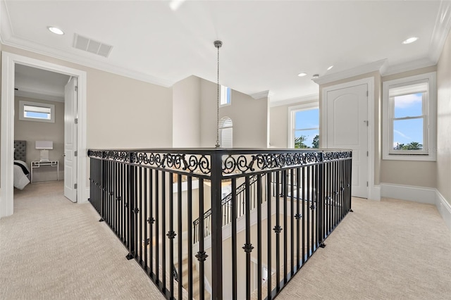 corridor featuring crown molding, plenty of natural light, and light carpet