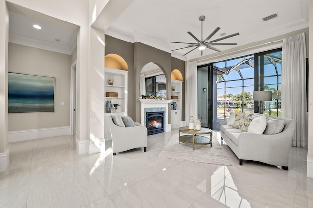 living room with ornamental molding, built in features, and ceiling fan