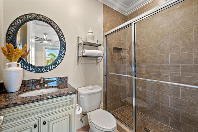 bathroom with vanity, an enclosed shower, ceiling fan, toilet, and crown molding