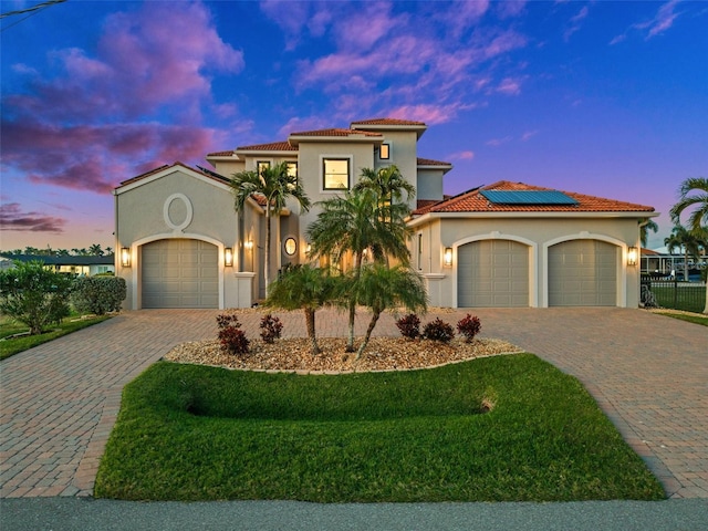 mediterranean / spanish-style home featuring a garage and solar panels