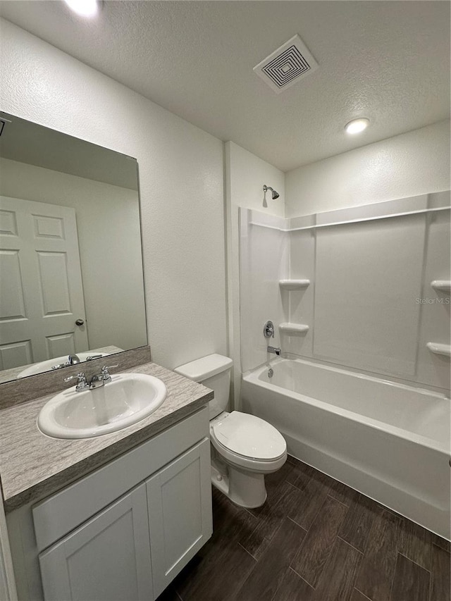 bathroom featuring toilet, visible vents, vanity, bathing tub / shower combination, and wood tiled floor