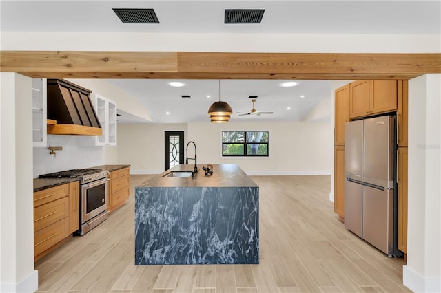 kitchen with stainless steel appliances, light hardwood / wood-style floors, premium range hood, sink, and light brown cabinetry