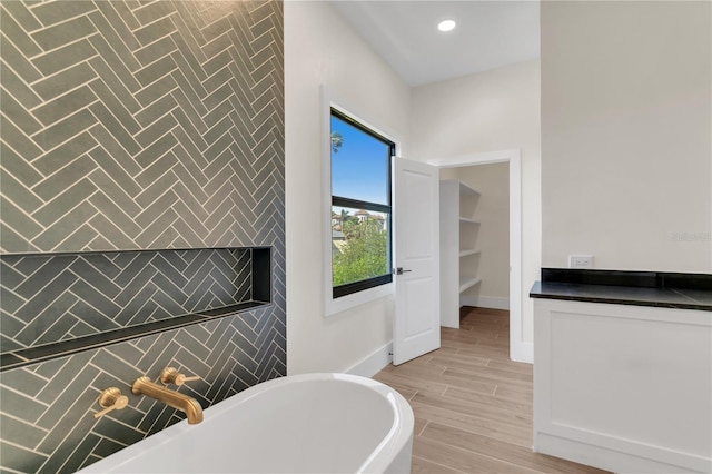 bathroom featuring tile walls and a bathtub
