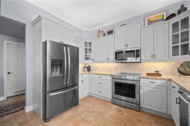 kitchen with appliances with stainless steel finishes, decorative backsplash, and white cabinets