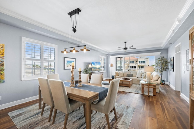 dining area with ornamental molding, dark wood-type flooring, and ceiling fan