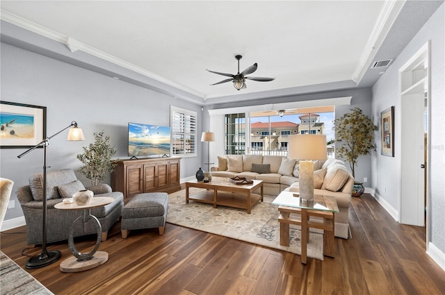 living room featuring a tray ceiling, dark hardwood / wood-style floors, and ceiling fan