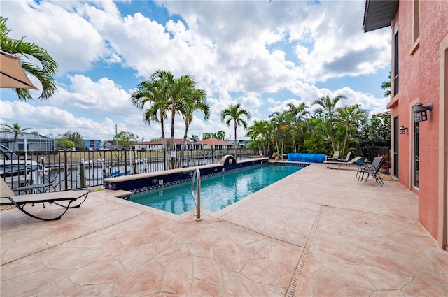 view of swimming pool with a water view and a patio