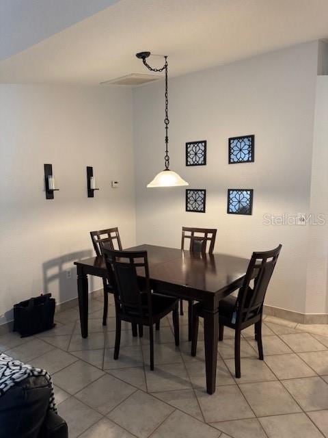 tiled dining room featuring baseboards