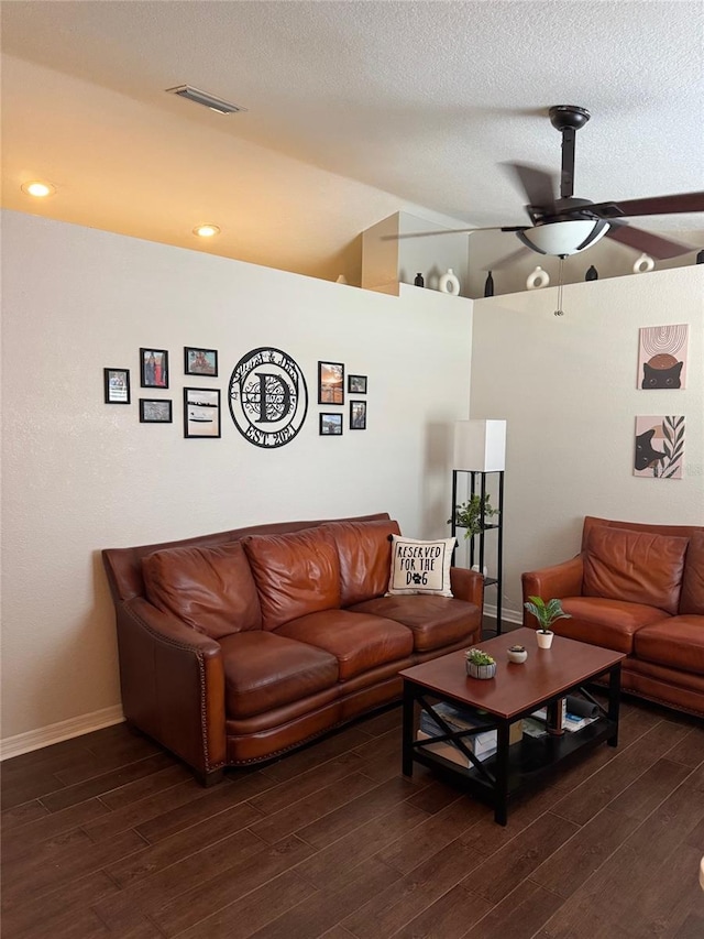 living area featuring visible vents, a textured ceiling, a ceiling fan, and dark wood-style flooring