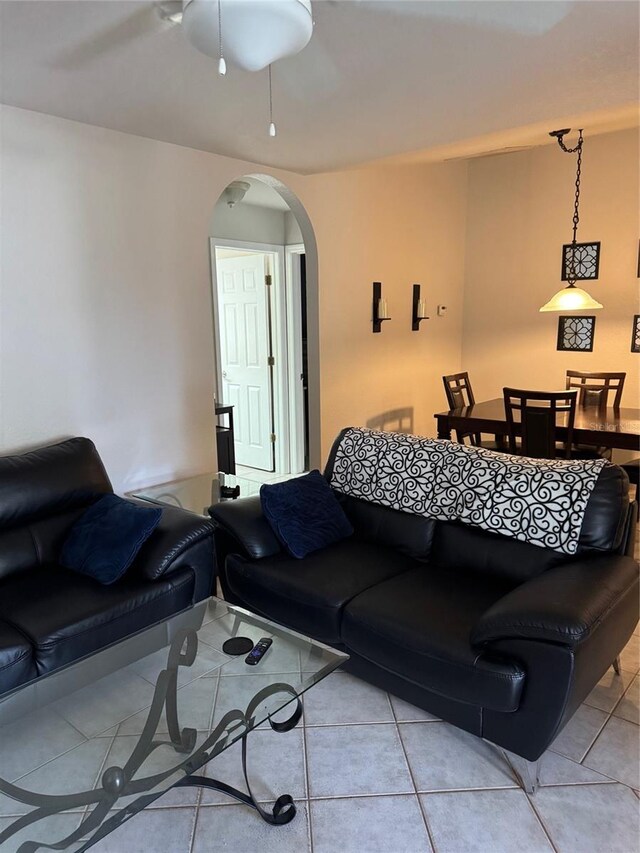 living area featuring arched walkways and light tile patterned floors