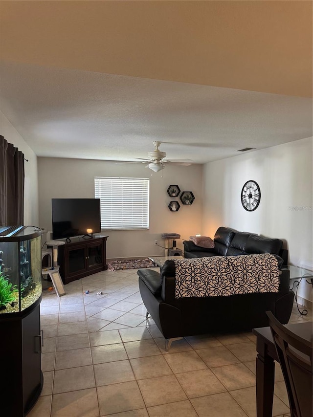 living area featuring light tile patterned floors, visible vents, and a ceiling fan