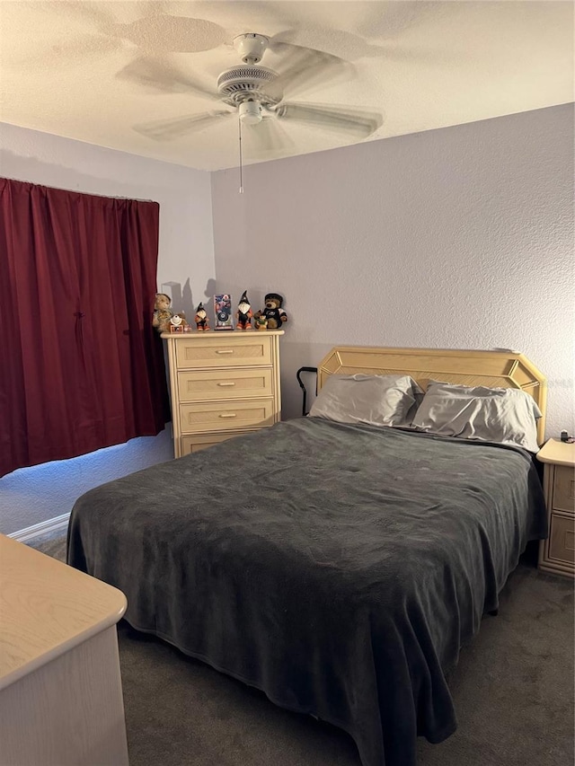 bedroom featuring a textured wall, dark carpet, and ceiling fan